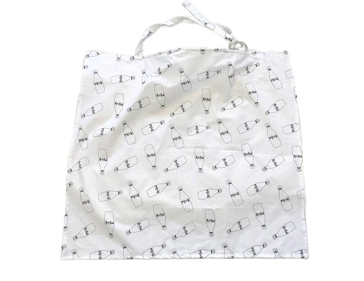 Жінка використовує стильну та зручну накидку для годування, що забезпечує комфорт та конфіденційність під час грудного вигодовування на природі.