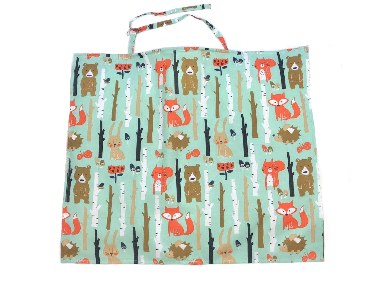 Жінка використовує стильну та зручну накидку для годування, що забезпечує комфорт та конфіденційність під час грудного вигодовування на природі.