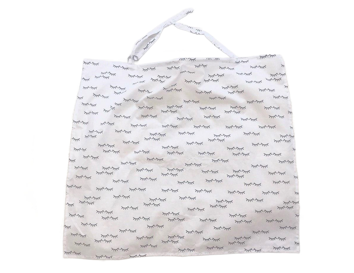 Жінка використовує стильну та зручну накидку для годування, що забезпечує комфорт та конфіденційність під час грудного вигодовування на природі.