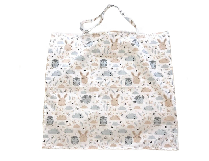 Жінка використовує стильну та зручну накидку для годування, що забезпечує комфорт та конфіденційність під час грудного вигодовування на природі.