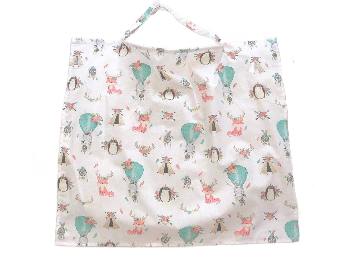 Жінка використовує стильну та зручну накидку для годування, що забезпечує комфорт та конфіденційність під час грудного вигодовування на природі.