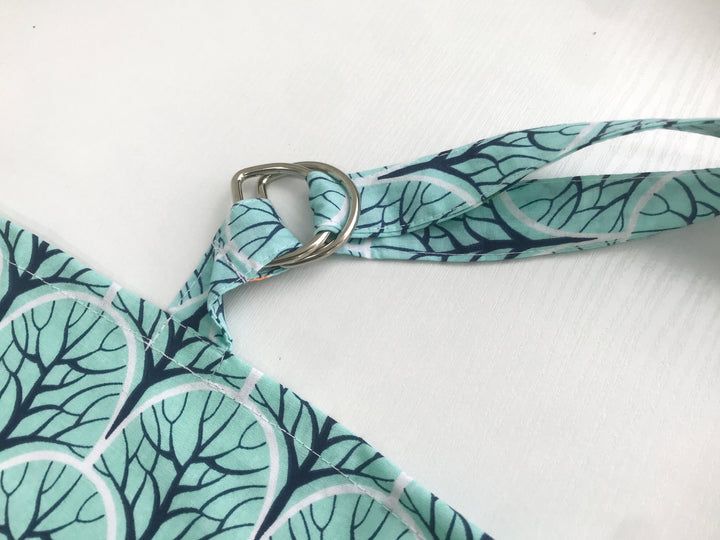 Жінка використовує стильну та зручну накидку для годування, що забезпечує комфорт та конфіденційність під час грудного вигодовування на природі.