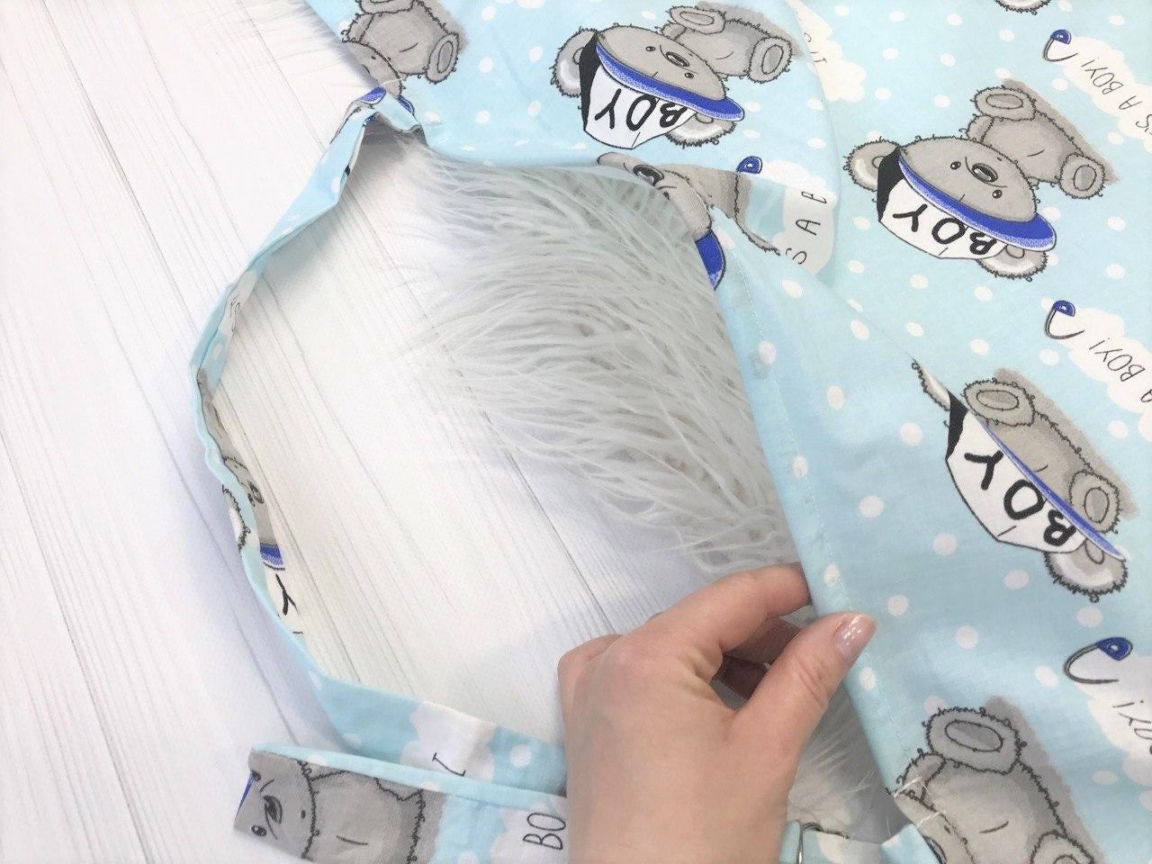 Жінка використовує стильну та зручну накидку для годування, що забезпечує комфорт та конфіденційність під час грудного вигодовування на природі.