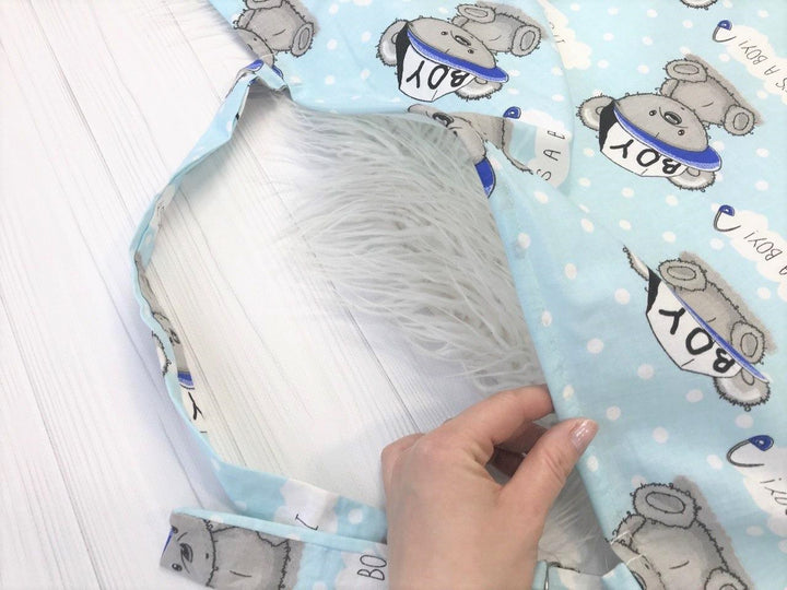 Жінка використовує стильну та зручну накидку для годування, що забезпечує комфорт та конфіденційність під час грудного вигодовування на природі.