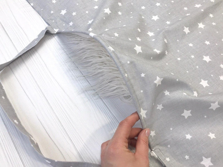 Жінка використовує стильну та зручну накидку для годування, що забезпечує комфорт та конфіденційність під час грудного вигодовування на природі.