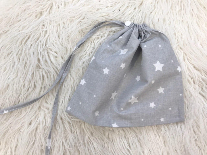 Жінка використовує стильну та зручну накидку для годування, що забезпечує комфорт та конфіденційність під час грудного вигодовування на природі.