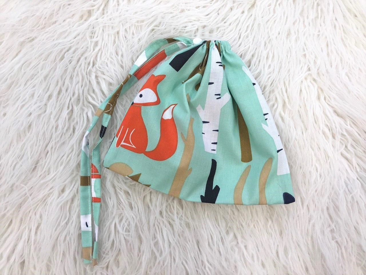 Жінка використовує стильну та зручну накидку для годування, що забезпечує комфорт та конфіденційність під час грудного вигодовування на природі.