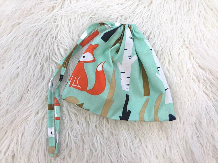 Жінка використовує стильну та зручну накидку для годування, що забезпечує комфорт та конфіденційність під час грудного вигодовування на природі.