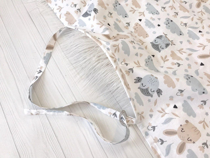 Жінка використовує стильну та зручну накидку для годування, що забезпечує комфорт та конфіденційність під час грудного вигодовування на природі.