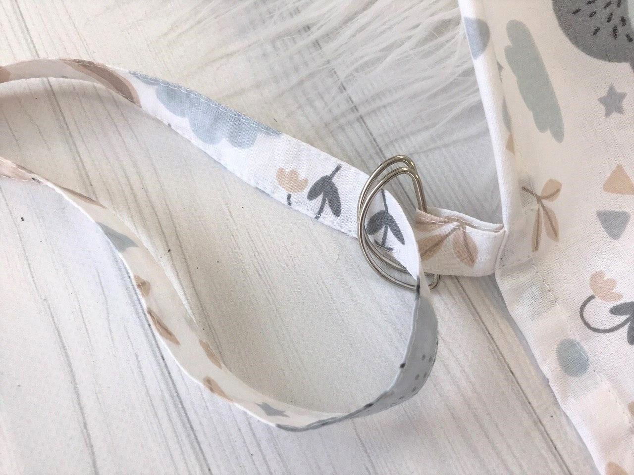 Жінка використовує стильну та зручну накидку для годування, що забезпечує комфорт та конфіденційність під час грудного вигодовування на природі.