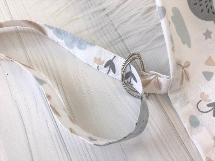 Жінка використовує стильну та зручну накидку для годування, що забезпечує комфорт та конфіденційність під час грудного вигодовування на природі.