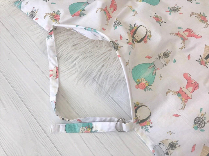 Жінка використовує стильну та зручну накидку для годування, що забезпечує комфорт та конфіденційність під час грудного вигодовування на природі.