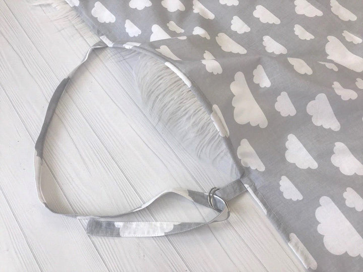 Жінка використовує стильну та зручну накидку для годування, що забезпечує комфорт та конфіденційність під час грудного вигодовування на природі.