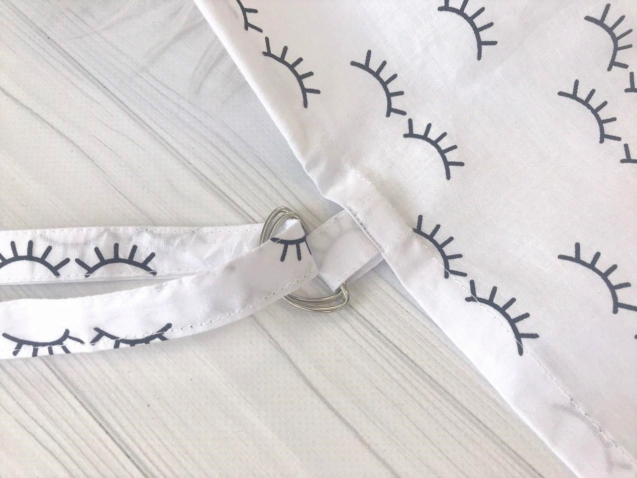 Жінка використовує стильну та зручну накидку для годування, що забезпечує комфорт та конфіденційність під час грудного вигодовування на природі.