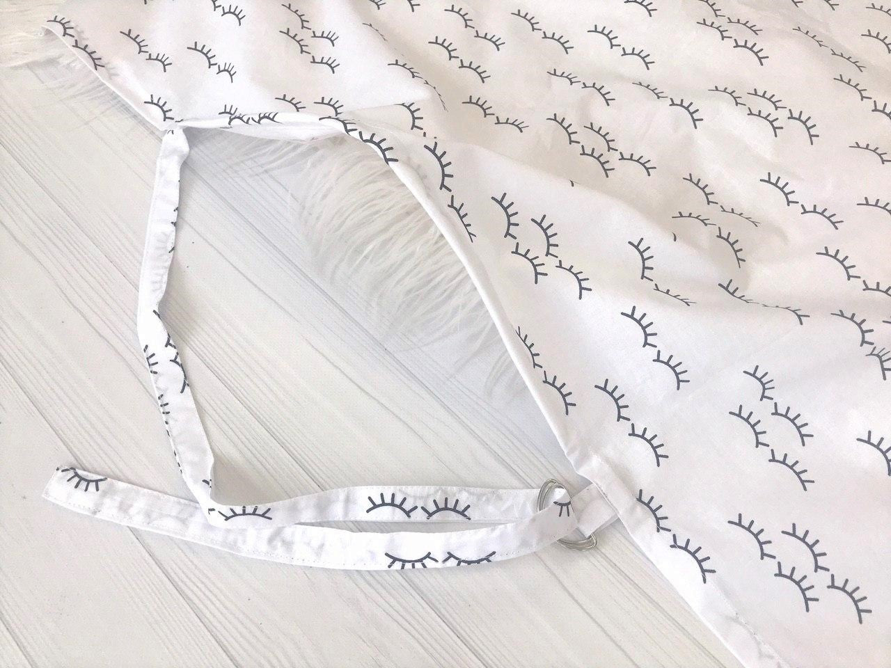 Жінка використовує стильну та зручну накидку для годування, що забезпечує комфорт та конфіденційність під час грудного вигодовування на природі.