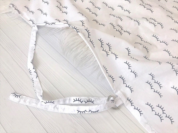 Жінка використовує стильну та зручну накидку для годування, що забезпечує комфорт та конфіденційність під час грудного вигодовування на природі.