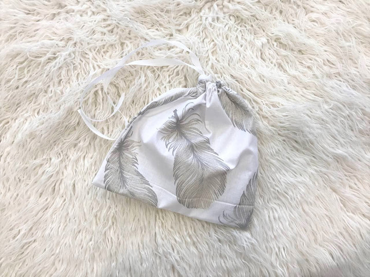 Жінка використовує стильну та зручну накидку для годування, що забезпечує комфорт та конфіденційність під час грудного вигодовування на природі.