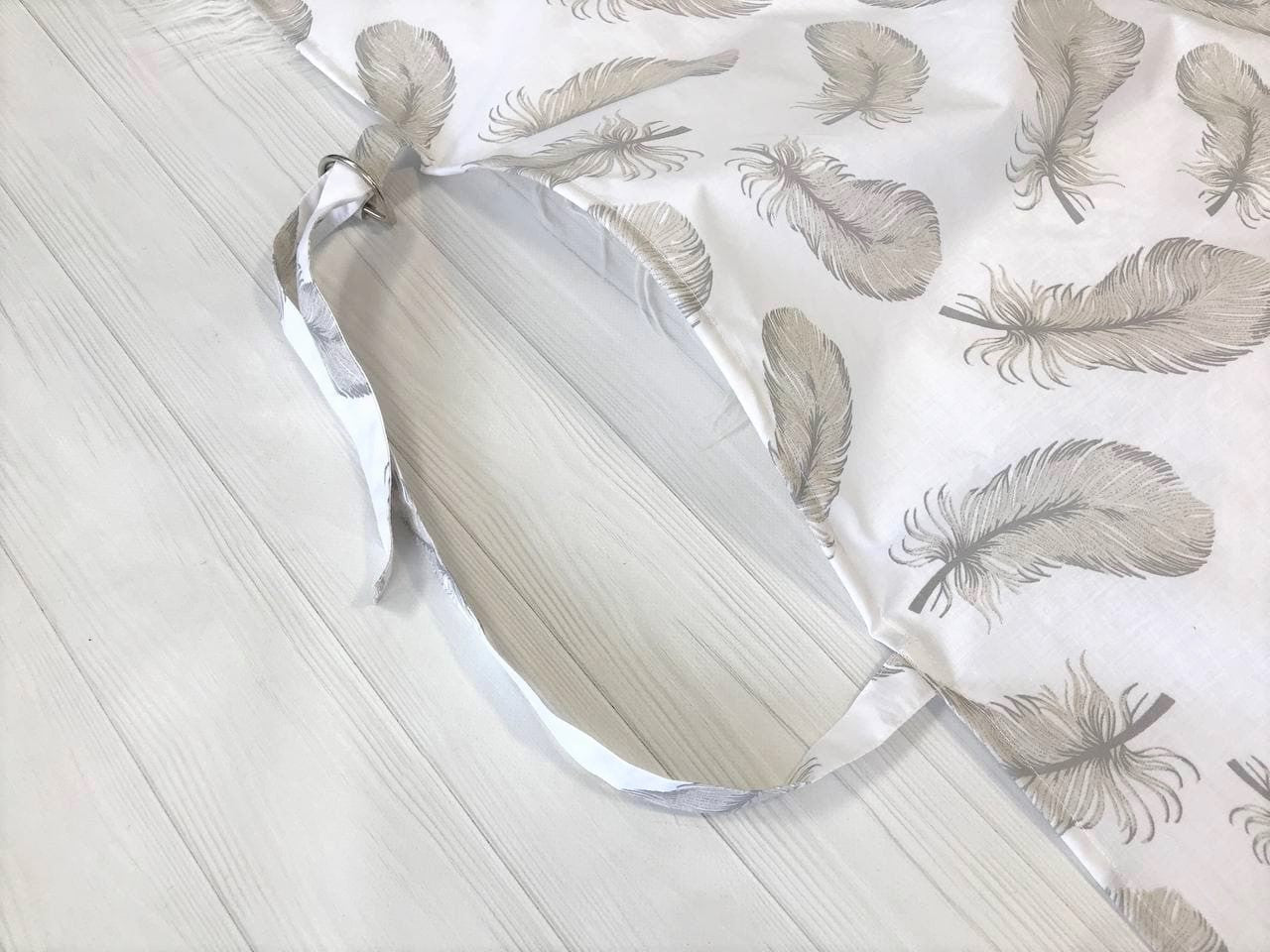 Жінка використовує стильну та зручну накидку для годування, що забезпечує комфорт та конфіденційність під час грудного вигодовування на природі.