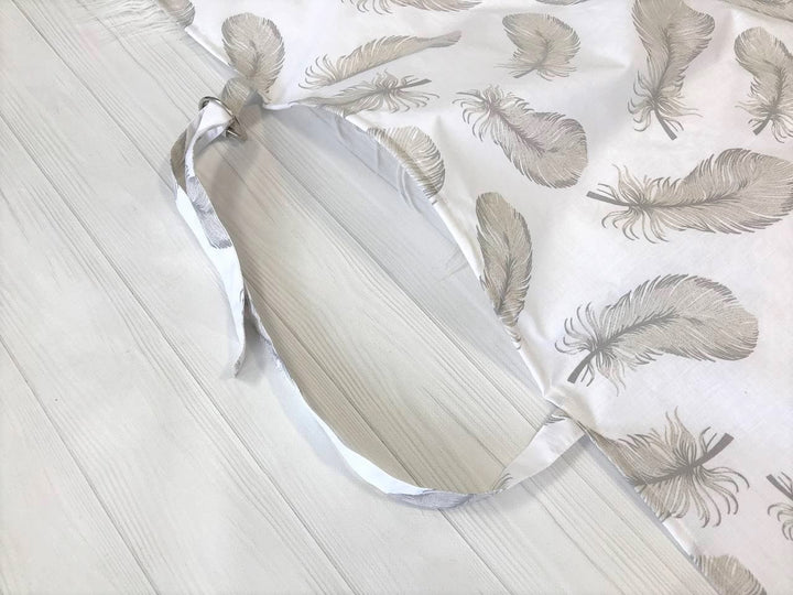 Жінка використовує стильну та зручну накидку для годування, що забезпечує комфорт та конфіденційність під час грудного вигодовування на природі.