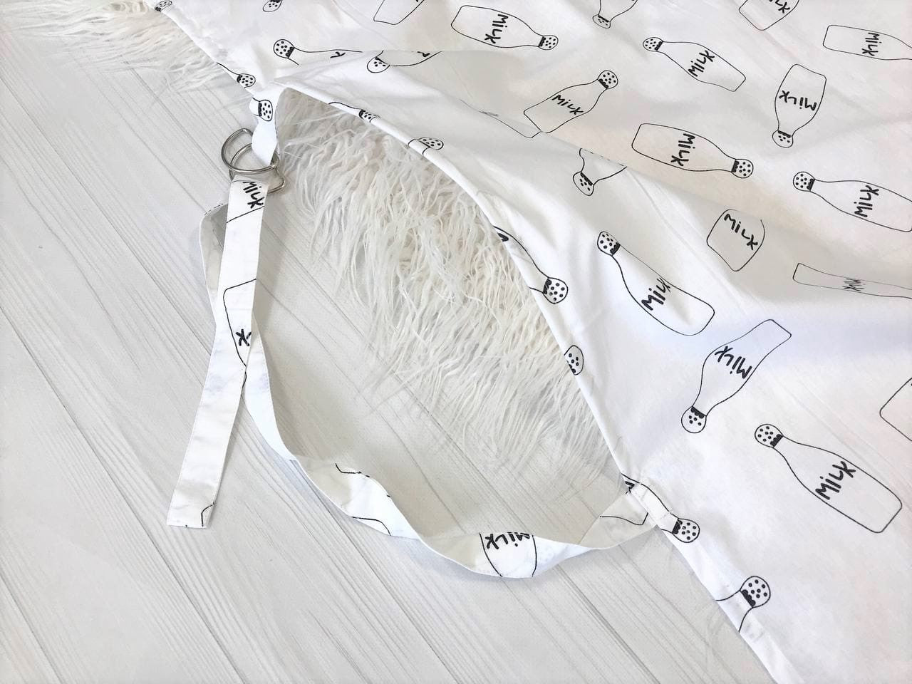 Жінка використовує стильну та зручну накидку для годування, що забезпечує комфорт та конфіденційність під час грудного вигодовування на природі.